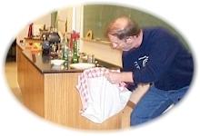 Man pulling table cloth out from under a table setting