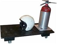 Helmet and fire extinguisher sitting on a rolling cart