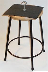 square of rubber with a hook attached sitting on top of a stool