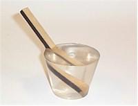 A stick cast in acrylic in a cup of water