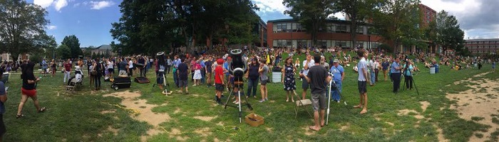 Telescopes set up on Sanford Mall with crowd of students surrounding them